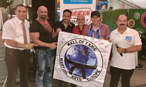 Zusammen mit seinen Kollegen Peter Sander und Thomas Stolkmann übergab er Koschig einen Scheck in Höhe von 700 Euro sowie ein Banner mit Unterschriften von Karateweltmeistern aus der ganzen Welt für die Goslarer Zivilcouragekampagne. Foto: WEISSER RING