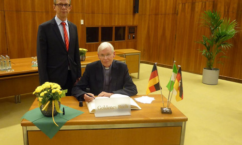 Weihbischof Dr. Nikolaus Schwerdtfeger trägt sich ins Goldene Buch der Stadt Wolfsburg ein. Foto: Stadt Wolfsburg