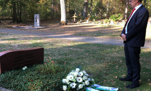 Oberbürgermeister Klaus Mohrs legt ein Blumengebinde auf dem Grab von Hugo Bork nieder. Foto: Stadt Wolfsburg