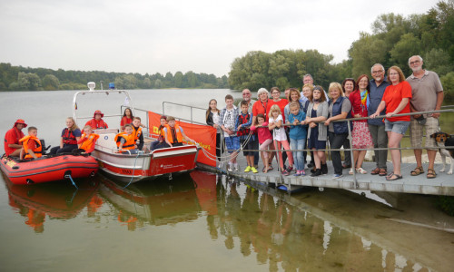 Die Kinder mit ihren Gasteltern und den Mitgliedern der DLRG, sowie die Boote „KNAX“ und „EULE“. Foto: Ulrike Hofmann