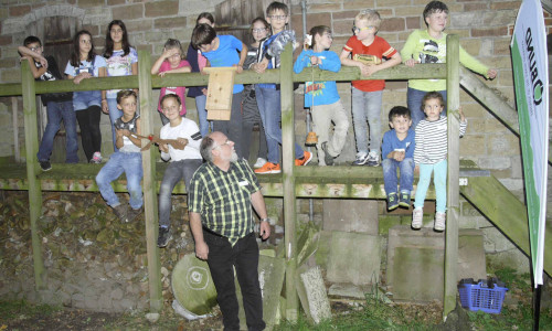 Thomas Keller und 15 Kinder mit Fledermauskasten und Fledermausattrappe vor der
Fledermaussuche mit den Detektoren. Foto: BUND