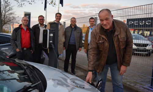 
Foto (Stadt Goslar): Axel Deipenau (von rechts) schließt den Akku des städtischen E-Autos an die von ihm finanzierte Ladesäule an. Die Projektbeteiligten Michael Hille, Mathias Brand, Dr. Oliver Junk, Arkadiusz Szczesniak und Jörg Döbbel schauen zu.