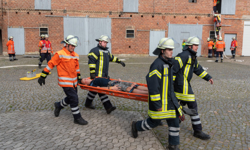 Eine verletzte Person wird abtransportiert während im Hintergrund eine weitere Person über eine Leiter gerettet wird. Fotos: Tanja Bischoff