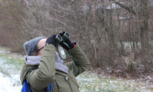 Eine Mitarbeiterin des NABU erfreut sich am Anblick eines Wintervogels. Foto: Alexander Panknin
