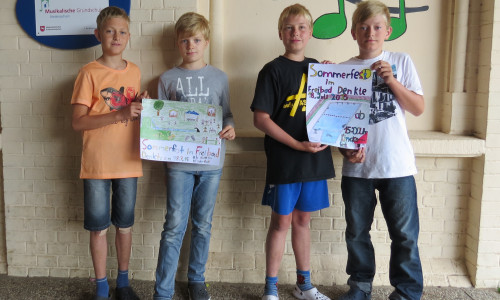 Tim und Sebastian, Klasse 4a und Louis und Leon Klasse 4b zeigen stolz ihre entworfenen Plakate zum Sommerfest