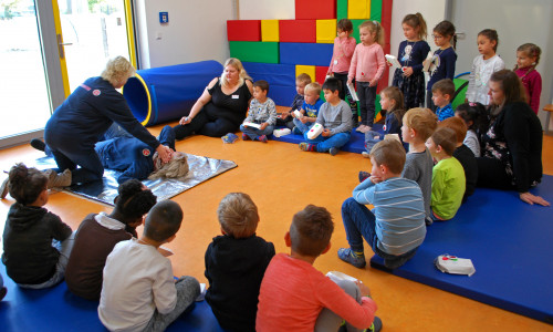 Johanniter-Trainerin Susanne Felka zeigt den Kindern, wie die stabile Seitenlage geht. Fotos: Natalia Shapovalova/Johanniter