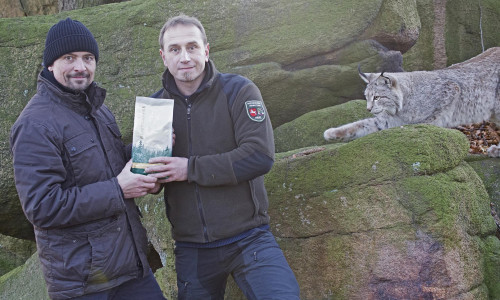 Ole Anders (rechts) übernimmt das erste offizielle "Luchs-Kaffeepaket" von Mark Schnibbe. Foto: Nationalpark Harz.