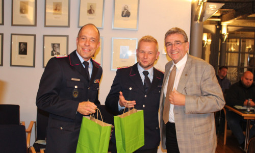 Bürgermeister Thomas Pink verteilte zur Ernennung von Olaf Glaeske (Mitte) und Marco Dickhut (li.) Präsente. Foto: Alexander Dontscheff