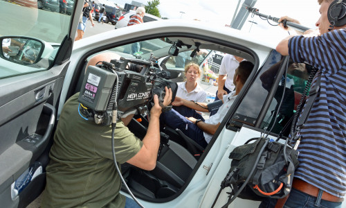 Malteserin Franziska Ehlert verkabelt Valentino Grein vor seinem Selbstversuch im Auto. Mit dabei: ein Team des NDR. Foto: Lukas/Malteser
