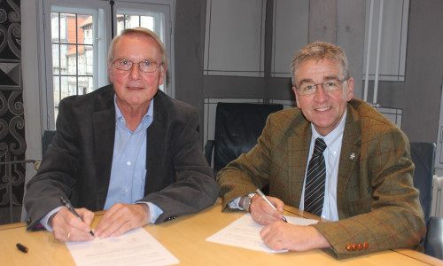 Heimatstiftungs-Vorsitzender Axel Gummert und Bürgermeister Thomas Pink unterzeichnen den Vertrag, der die Mittagsverpflegung in den Kitas sichert. Foto: Anke Donner 
