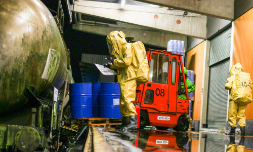 In Kontaminations-Schutzkleidung prüfen Einsatzkräfte der Feuerwehr den mit giftigem Stoff gefüllten Kesselwagen. Fotos/Video: Werner Heise