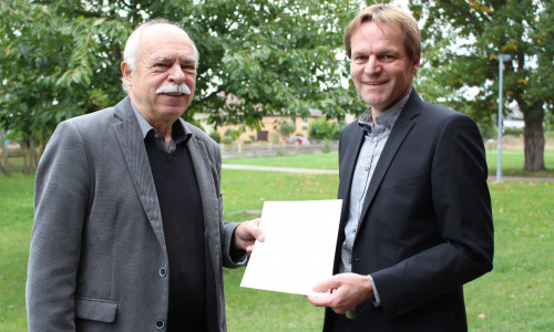 Der stellvertretende Bürgermeister Rolf Naue übergibt die Ernennungsurkunde zum Bürgermeister an seinen Sohn Jens Naue. 