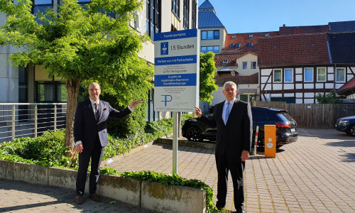 Von links: Stefan Honrath und Rainer Falkenhagen von der Volksbank BraWo weisen auf die neue Parkscheibenpflicht für die Nutzung des Volksbank-Parkplatzes am Windmühlenwall hin.
