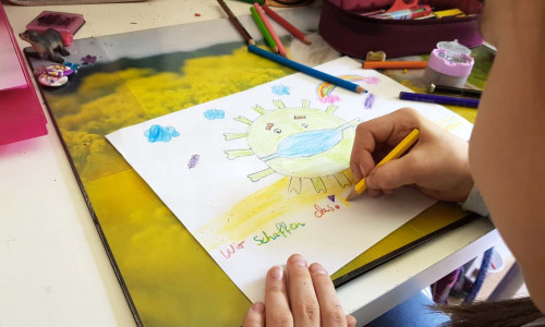 Ein Kind beim Malen eines Corona-Bildes.