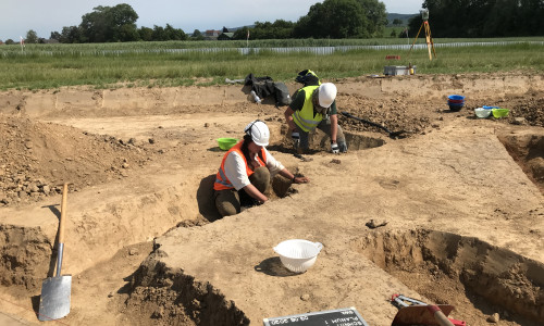 Archäologen aus Göttingen untersuchen den Boden auf Kulturgüter. Auch sie tragen Schutzkleidung.