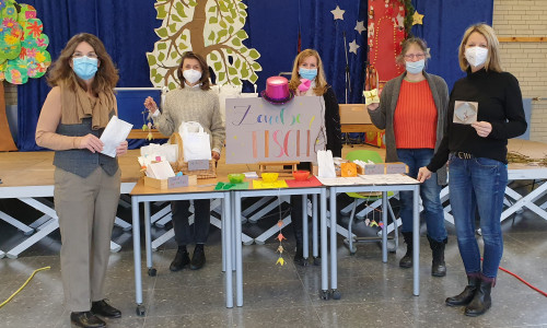 Mitarbeitende der Heidgartenschule präsentieren Bastelsets am "Zaubertisch". 