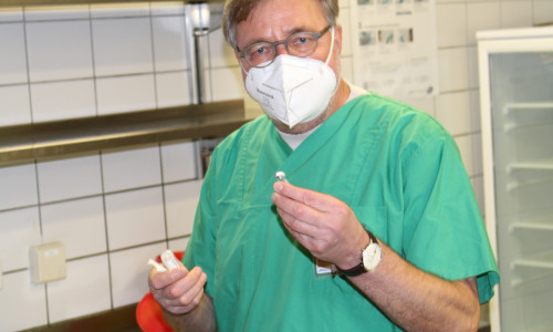 Der medizinische Leiter des Impfzentrums Prof. Dr. Karl Wessel erklärt, wie der Impfstoff angerührt werden muss.
