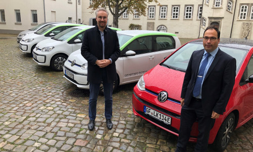 Dr. Thomas Walter (Erster Kreisrat, links) und Jochen Koslowski (Leitung Fachbereich Zentrale Dienste) präsentieren die neuen E-Fahrzeuge im Fuhrpark der Kreisverwaltung. 