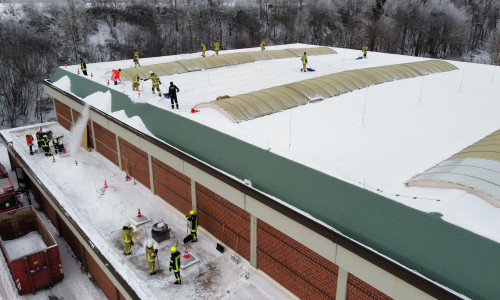 Feuerwehrleute befreien das Dach der Kanthalle von den Schneemassen. 