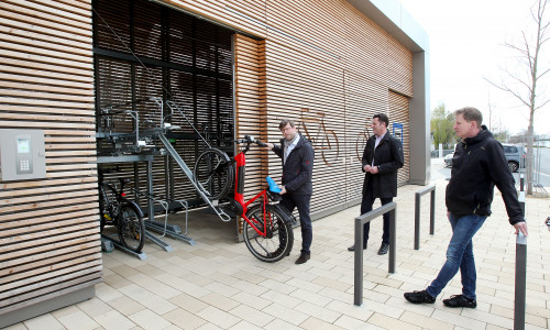 Fahrradbeauftragter Oliver Bley schiebt ein Rad in die Box, daneben BM Matthias Nerlich und Karsten Moritz, Fachbereichsleiter Bauverwaltung.  