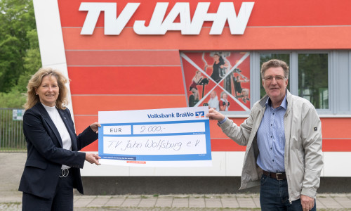 Claudia Kayser, Leiterin der Direktion Wolfsburg der Volksbank BraWo, übergibt die Spende symbolisch an Dirk Räke-Maresté, Geschäftsführer des TV Jahn Wolfsburg.