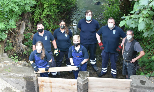 Mitglieder der Jugendfeuerwehr Winnigstedt und der Einsatzabteilung beim Einbau der neuen Holzbohlen. 