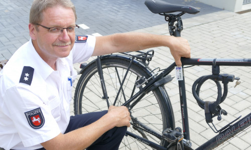 Klaus Ahne (Polizeiinspektion Gifhorn) demonstriert, an welcher Stelle das Fahrradkennzeichen angebracht wird. 