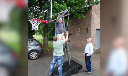 Aufbau der neuen Basketballkörbe. Auf der Leiter stehend der 2. Bürgermeister Helmut Scheffler, davor stehend der MTV-Vorsitzende Carsten Voigt und rechts stehend der Bürgermeister Bruno Polzin.