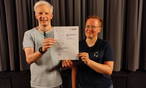 Stabübergabe im Universum Filmtheater Braunschweig: Tobias Jung und Anke Hagenbüchner freuen sich über die jüngste Auszeichnung des Programmkinos durch die Nordmedia, Juli 2021.