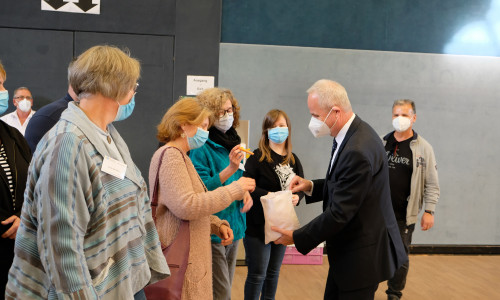 Landrat Thomas Brych verteilt Gutscheine als kleines Dankeschön an die Belegschaft des Impfzentrums.