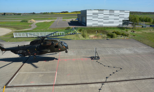 Der He­li­ko­pter CH-53 der Bun­des­wehr flog bei den Ver­su­chen in 2 bis 12 Me­tern Hö­he über dem Roll­feld. Fünf Ka­me­ras nah­men ihn und die Luft­wir­bel an den Ro­to­ren da­bei in den Blick.