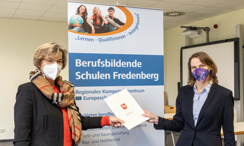 Schuldezernentin Andrea Hartmann (re.) übergibt Anja Wolfgram-Funke die Urkunde.