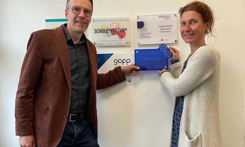 Das Foto zeigt exemplarisch die Übergabe eines Schildes am Theodor-Heuss-Gymnasium Wolfenbüttel: Prof. Dr. Andreas Ligocki von der Ostfalia und Dr. Anja Riegert vom THG Wolfenbüttel.