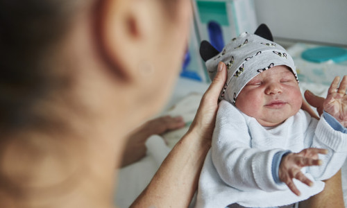 Eine Hebamme der Asklepios Harzkliniken mit einem Baby.
