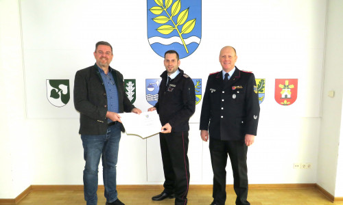 Gemeindebürgermeister Andreas Busch (li.) und Gemeindebrandmeister Simon Rebel (re.) gratulieren Jan Wehrstedt.
