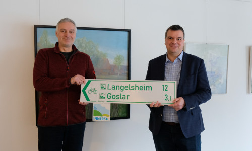 Tim Schwarzenberger (links) und Landrat Dr. Alexander Saipa präsentieren die Radwegweiser, die das bestehende Radwegenetz im Landkreis bald ausweisen sollen. Mit diesem Schritt sollen auch die im Landkreis verlaufenden Radfernwege in die einheitliche Beschilderung integriert werden.