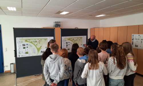 Landschaftsarchitekt Frank von Bargen erklärt den Kindern die Spielplatzplanungen.