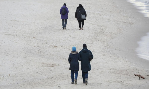 Paare gehen am Strand spazieren