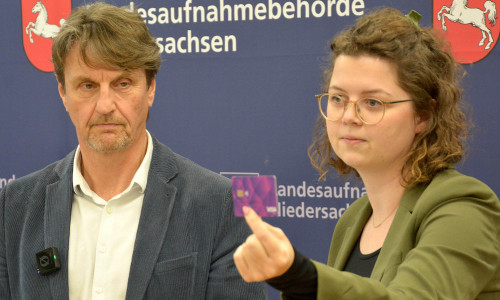 Präsident Klaus Dierker und Ronja Kuhls von der Landesaufnahmebehörde Niedersachsen präsentieren die Bezahlkarte.