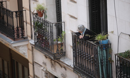 Seniorin schaut von einem Balkon (Archiv)