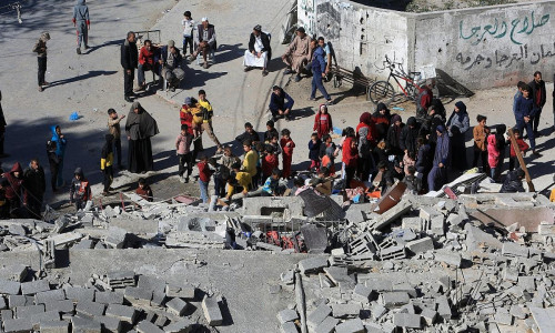 Menschen versammeln sich an einem zerstörten Haus in Rafah am 12.03.2024