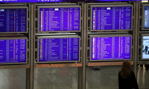 Frau vor Informationstafel am Frankfurter Flughafen