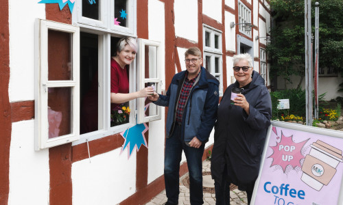 Freuen sich über heißen Kaffee: Andreas Meyer (Mitte) und Monika Kiekenap-Wilhelm (rechts) bekommen von einer Museumsmitarbeiterin ihren Coffee to go ausgehändigt.
