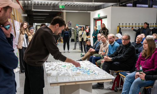 Julian Numberger von NUWELA Büro für Städtebau und Landschaftsarchitektur erläutert den Entwurf am Modell bei der öffentlichen Zwischenpräsentation im März 2024 am Campus Nord