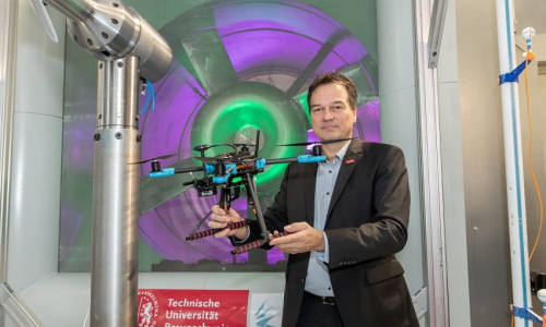 Prof. Dr. Jens Friedrichs, Leiter des Instituts für Flugantriebe und Strömungsmaschinen, mit Drohne im neuen Windkanal der TU Braunschweig.