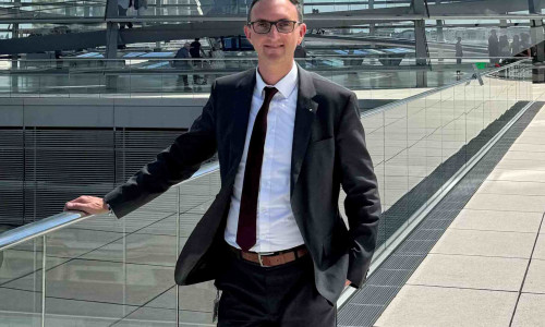 Alexander Jordan vor der Kuppel des Bundestages.