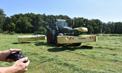 Das Symbolbild zeigt einen Traktor mit Front- und Heckmähwerk sowie einen Controller. An verschiedenen Möglichkeiten und Rahmenbedingungen der externen Steuerung als Schritt zur Automatisierung landwirtschaftlicher Maschinen und Prozesse wird im Projekt GESAL gearbeitet.