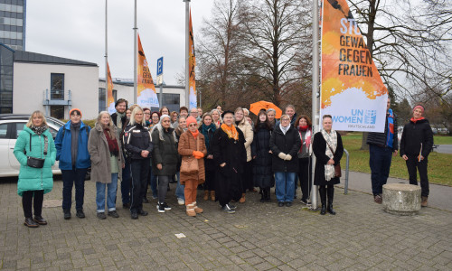 Gruppenbild auf dem Rathausvorplatz beim Hissen der orangen Flagge.