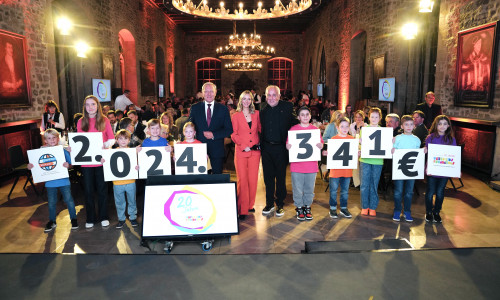 Kinder mit der Spendensumme, in der Mitte von links nach rechts: Jürgen Brinkmann, Jenny Richter (Moderatorin RTL Nord), Robert Lübenoff.
