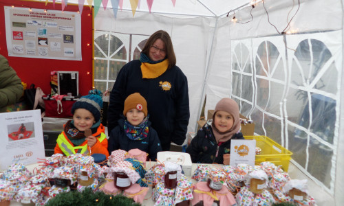 Tanja Tielemann von der Kita mit drei kleinen Strolchen beim Marmeladenverkauf auf dem Weihnachtsmarkt.